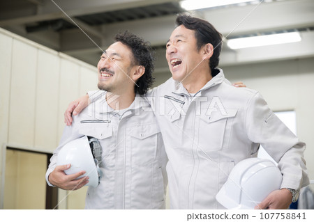 Factory manufacturing and delivery industry workers with helmets and smiling faces looking up, looking for a job change or hiring 107758841