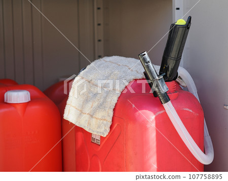Red kerosene plastic tank and battery-powered auto pump in the storeroom 107758895