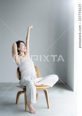 Full body of a woman stretching her arms in the morning sun 107759225
