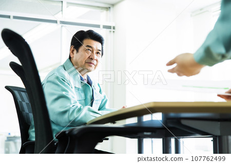 Middle-aged businessman wearing work clothes having a meeting in an office conference room 107762499