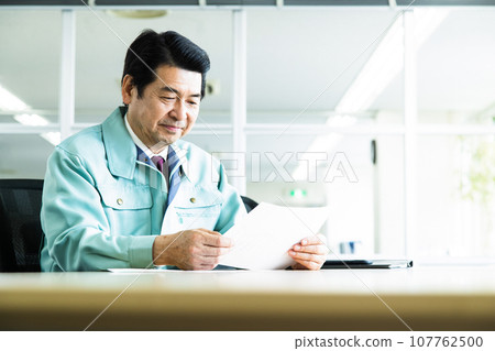Middle-aged businessman wearing work clothes having a meeting in an office conference room 107762500