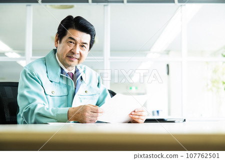 Middle-aged businessman wearing work clothes having a meeting in an office conference room Middle-aged businessman wearing work clothes having a meeting in an office conference room 107762501