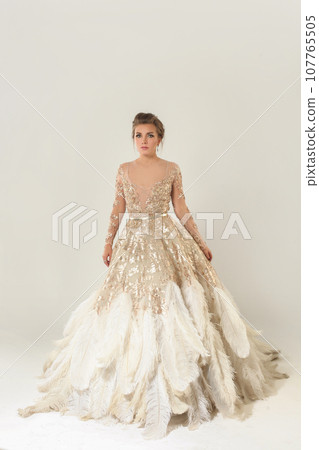 Fashion portrait of young beautiful woman in gold dress. Brunette glamour lady withhairstyle Fashion portrait of young beautiful woman in gold dress. Brunette glamour lady withhairstyle 107765505