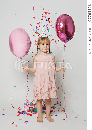 Portrait of happy kid with balloon in colorful confetti rain on white background Portrait of happy kid with balloon in colorful confetti rain on white background 107765598