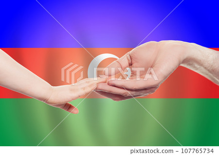 Azerbaijani baby and parent hands on the background of flag of Azerbaijan Help 107765734