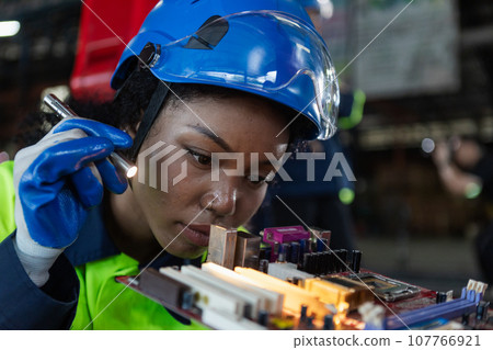 Female african american professional technician checking computer motherboard. Female african american professional technician checking computer motherboard. 107766921
