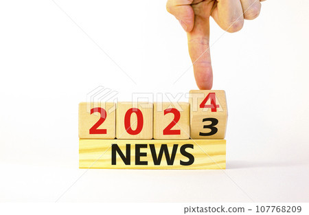 2024 News new year symbol. Businessman turns a wooden cube and changes words News 2023 to News 2024. Beautiful white table white background, copy space. Business 2024 news new year concept. 107768209