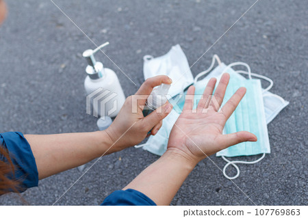 The woman use alcohol to clean hands for prevention of coronavirus virus outbreak. COIVD 19 107769863