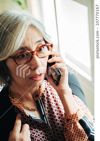 Senior woman talking by the window 107770167