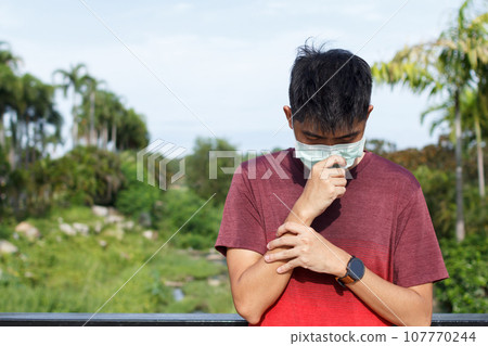 Sport Young man feeling unwell and wearing face mask 107770244