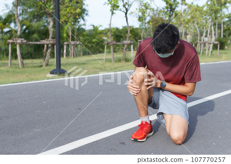 Sport man suffering with pain on sports running knee injury after running.Injury from workout concept 107770257