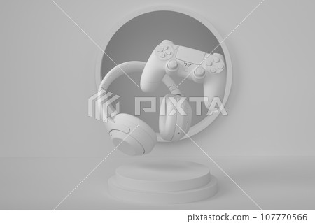 Set of video game joystick and headphones on monochrome podium 107770566