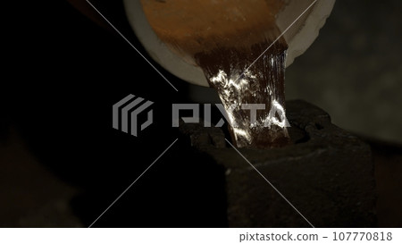 Shaping molten metal. Steel Factory. Liquid iron flowing in steelworks. Industrial details of metallurgic factory or plant. Details of smelting metal 107770818