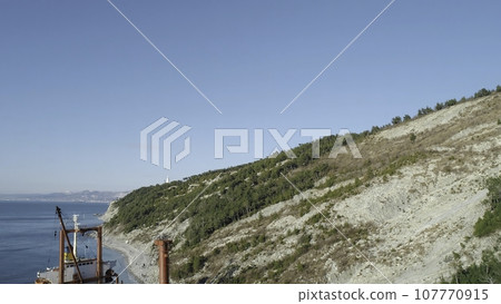 Close-up of large red and black container ship on the dock near the shore. Shot. Sea transportations Close-up of large red and black container ship on the dock near the shore. Shot. Sea transportations 107770915