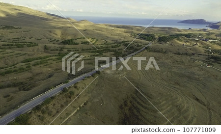 Desert road, Aerial footage. Shot. Desert and the road surrounded by sea aerial view 107771009