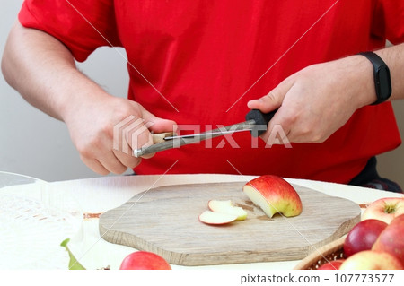 Man sharpening kitchen knife with special tool 107773577