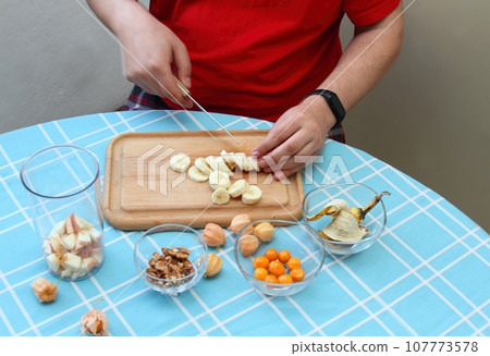 Man's hands cutting banana for sweet smoothie 107773578