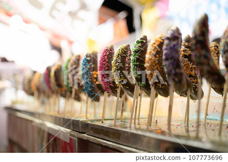 Many colorful chocolate bananas lined up 107773696