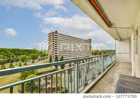 a balcony with blue sky and white clouds in the background, as seen from an apartment building's balcony a balcony with blue sky and white clouds in the background, as seen from an apartment building's balcony 107773780