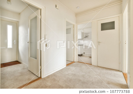 an empty room with white walls and door handles on the doors are closed to let in light into the room 107773788