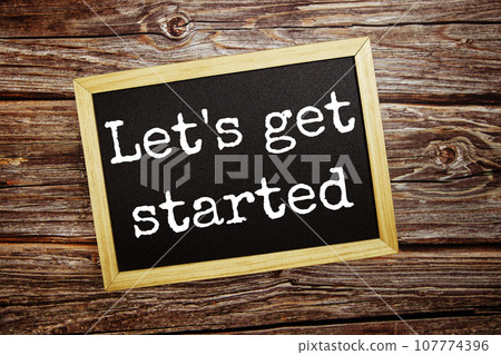Let's get started  write on blackboard top view on wooden background 107774396