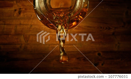Bottle of Whiskey with Pouring Liquid. 107776031