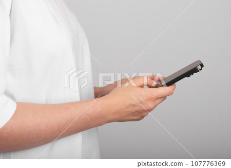 Berlin, Germany September 16 2023 Hands holding mobile phone, using smartphone Berlin, Germany September 16 2023 Hands holding mobile phone, using smartphone 107776369