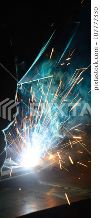 Welder uses torch to make sparks during manufacture of metal equipment Welder uses torch to make sparks during manufacture of metal equipment 107777330