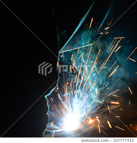 Welder uses torch to make sparks during manufacture of metal equipment 107777332