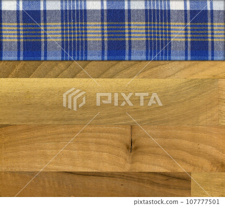 Blue white plaid napkin on walnut wooden floor table or cutting board Blue white plaid napkin on walnut wooden floor table or cutting board 107777501