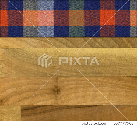 Colourful plaid napkin on walnut wooden floor table or cutting board 107777503