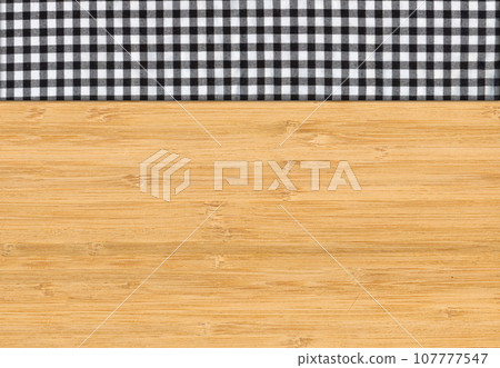 Black white plaid napkin on bamboo wooden floor table or cutting board Black white plaid napkin on bamboo wooden floor table or cutting board 107777547