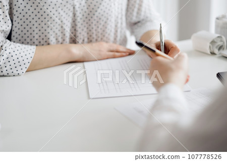 Two accountants using a laptop computer and calculator for counting taxes at white desk in office. Teamwork in business audit and finance Two accountants using a laptop computer and calculator for counting taxes at white desk in office. Teamwork in business audit and finance 107778526