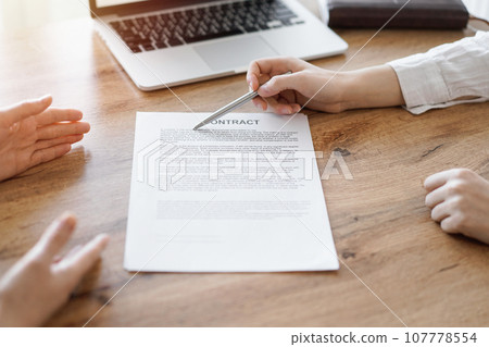 Business people discussing contract signing deal while sitting at the wooden table in office. Partners or lawyers working together at meeting. Teamwork, partnership, success concept Business people discussing contract signing deal while sitting at the wooden table in office. Partners or lawyers working together at meeting. Teamwork, partnership, success concept 107778554
