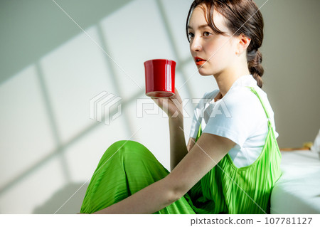 A woman drinking coffee 107781127