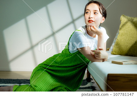 Young woman sitting on the sofa and thinking Young woman sitting on the sofa and thinking 107781147