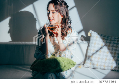 A woman sitting on a sofa A woman sitting on a sofa 107781164