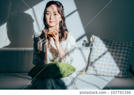 A woman sitting on a sofa A woman sitting on a sofa 107781166