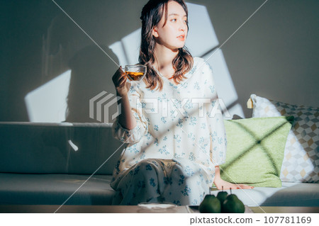 A woman sitting on a sofa 107781169