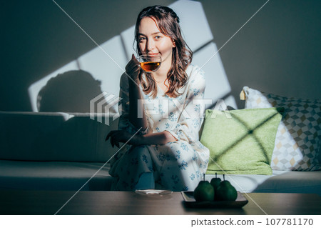 A woman sitting on a sofa 107781170