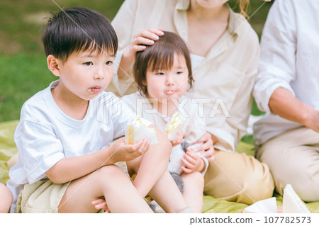 Children, parents, and families eating sandwiches on a picnic (meal, lunch, rice, growing period, plated meal) Children, parents, and families eating sandwiches on a picnic (meal, lunch, rice, growing period, plated meal) 107782573