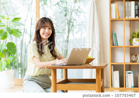 A young lady watching a computer 107783407