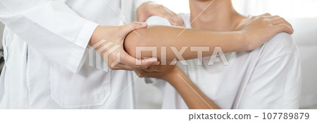 Female physiotherapists provide assistance to male patients with elbow injuries and examine patients in rehabilitation centers. Physiotherapy concepts 107789879