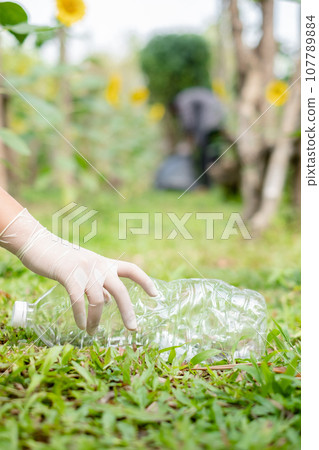 garbage collection, volunteer team pick up plastic bottles, put garbage in black garbage bags to clean up at parks, avoid pollution, be friendly to the environment and ecosystem garbage collection, volunteer team pick up plastic bottles, put garbage in black garbage bags to clean up at parks, avoid pollution, be friendly to the environment and ecosystem 107789884