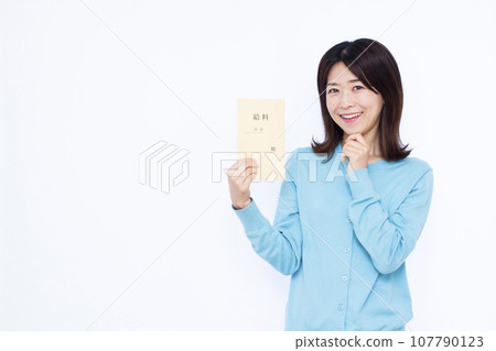 A woman in her 30s holding a salary bag and thinking with a smile in front of a white background 107790123