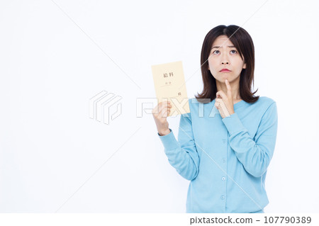一名 30 多歲的女性在白色背景前拿著薪資袋，很擔心 107790389