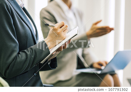A woman taking notes during a meeting/business negotiation 107791302