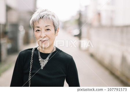一位優雅的日本女人,頭髮花白,走在小巷裡 一位優雅的日本女人,頭髮花白,走在小巷裡 107791573