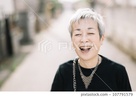 An elegant Japanese woman with gray hair walking down an alley 107791579