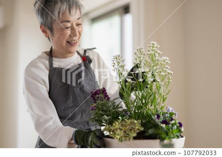 An elegant Japanese woman with gray hair planting trees An elegant Japanese woman with gray hair planting trees 107792033